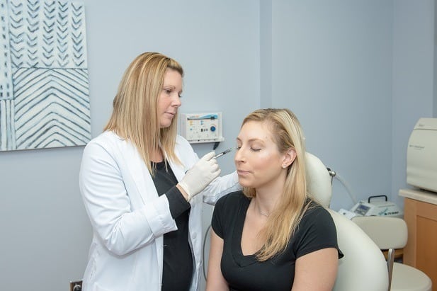 Woman getting a botox injection front side