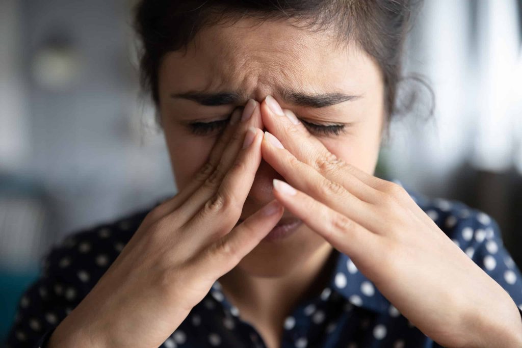 Woman rubbing her nose