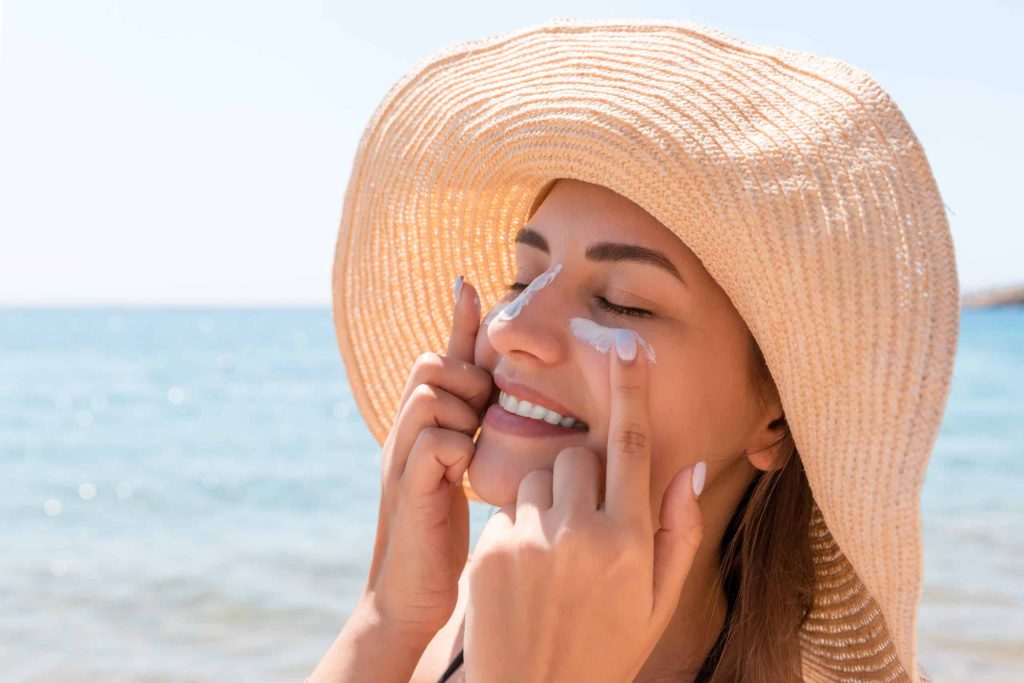 Woman applying sunscreen to her face