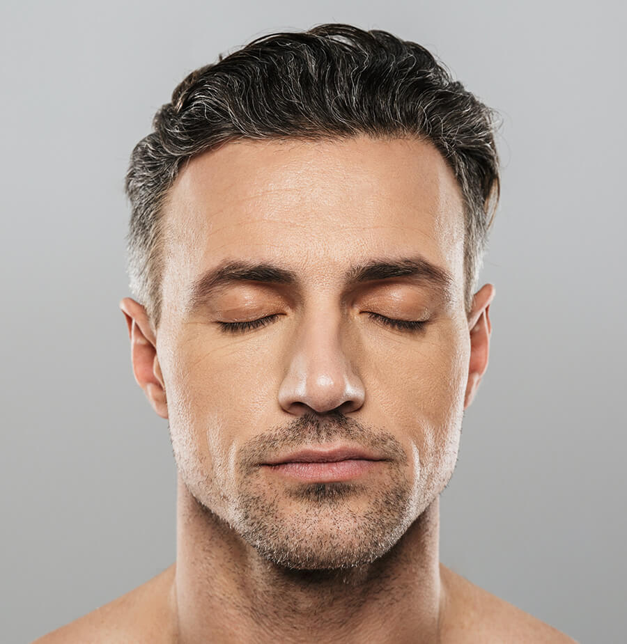 Headshot of male model with a head full of hair and his eyes closed