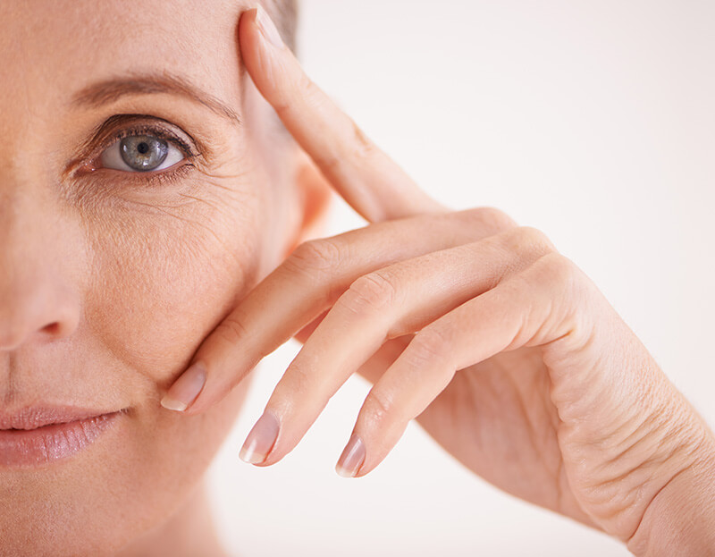 Mature woman touching her face