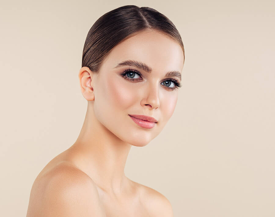 headshot of a female model with bare shoulders and clear smooth skin