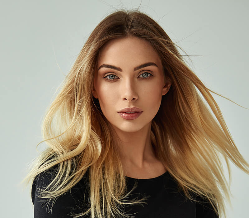 headshot of female model with flowing hair and thin facial features - mobile version