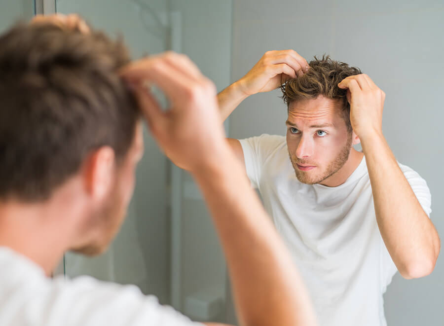 Man looking at his hair in the mirror