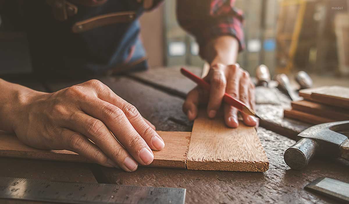 A carpenter adjusting wooden pieces