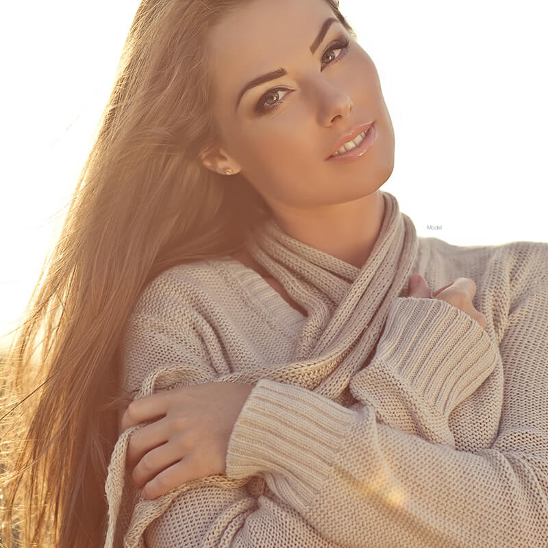Female model in a warm sweater in the sun