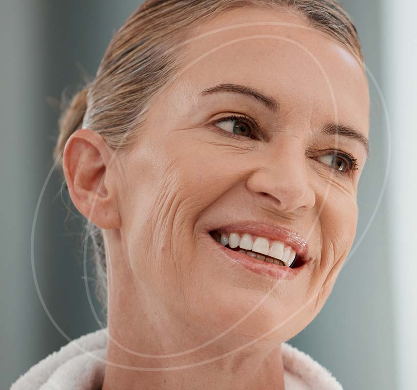 Mature woman in a white robe smiling