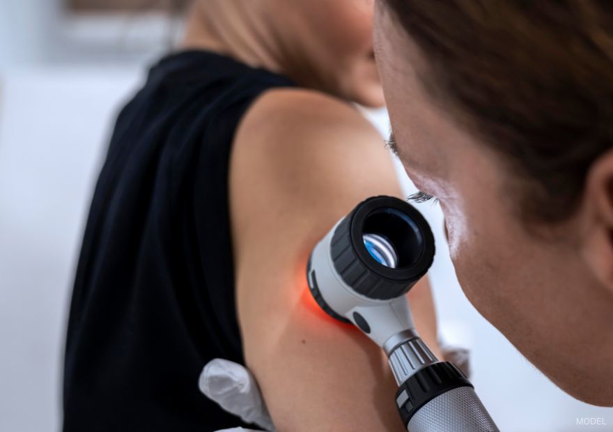 medical professional looking at a woman's arm using a manifier